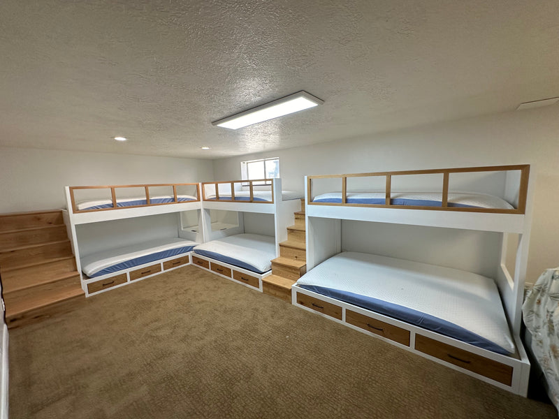 Custom wood bunk beds in a room with carpeted floor and white walls.